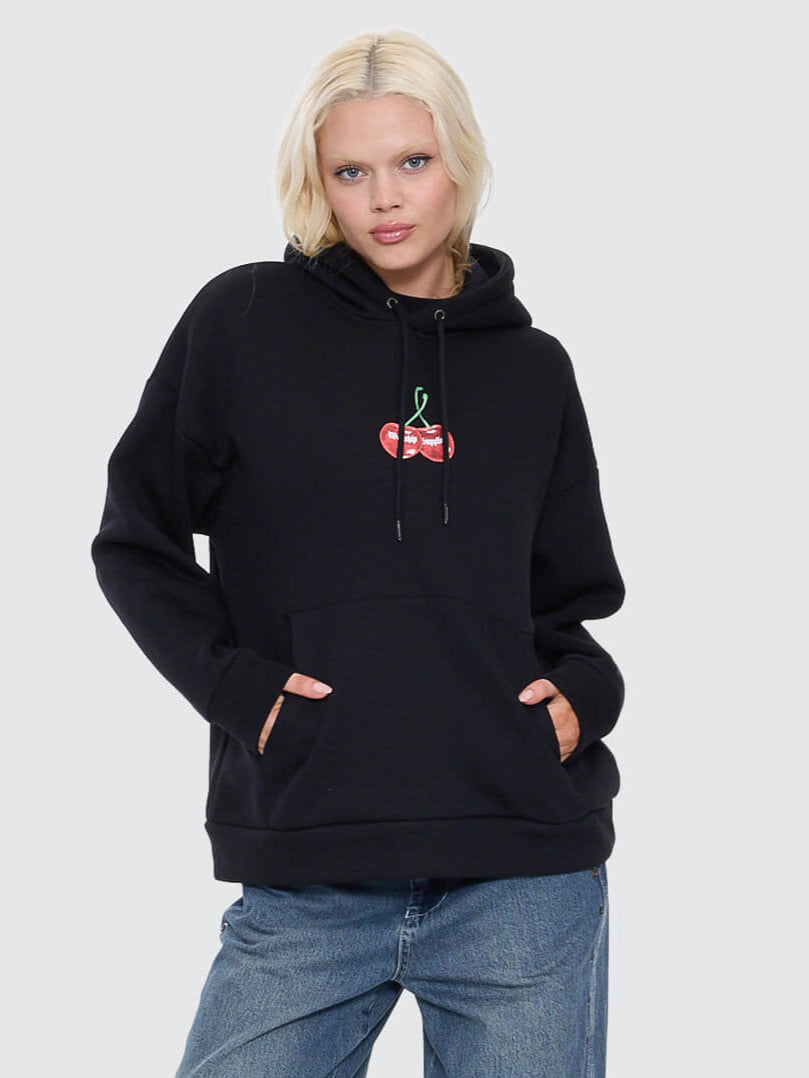 Person wearing a black hoodie with a red logo and blue jeans on a white background